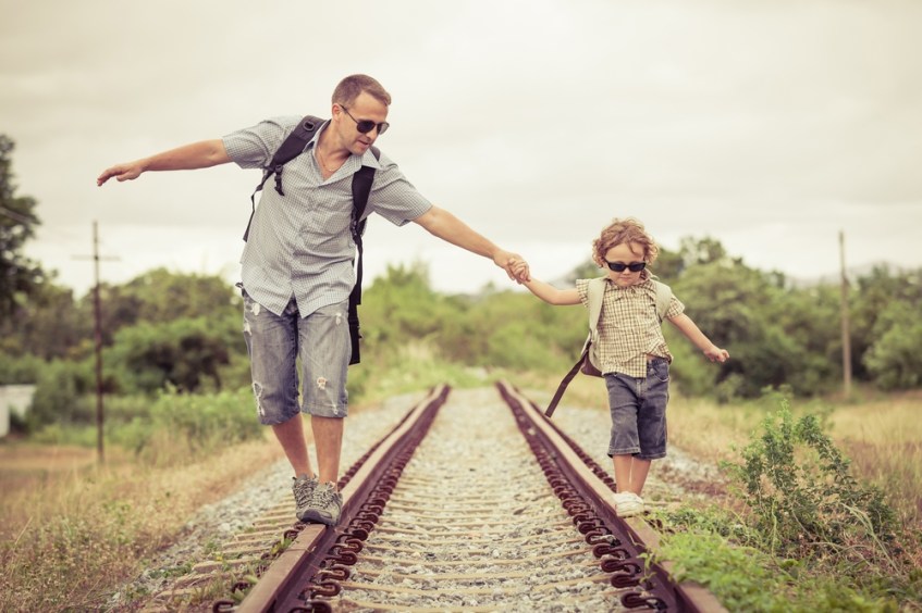 father-son-walking-railway-track